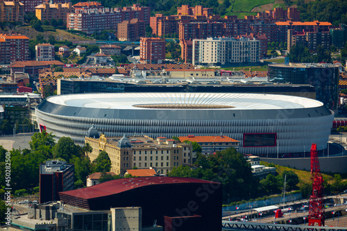 View of building of football San Mames Stadium (Nuevo San Mames) in Spanish city of Bilbao on background of modern summer cityscape.. photo