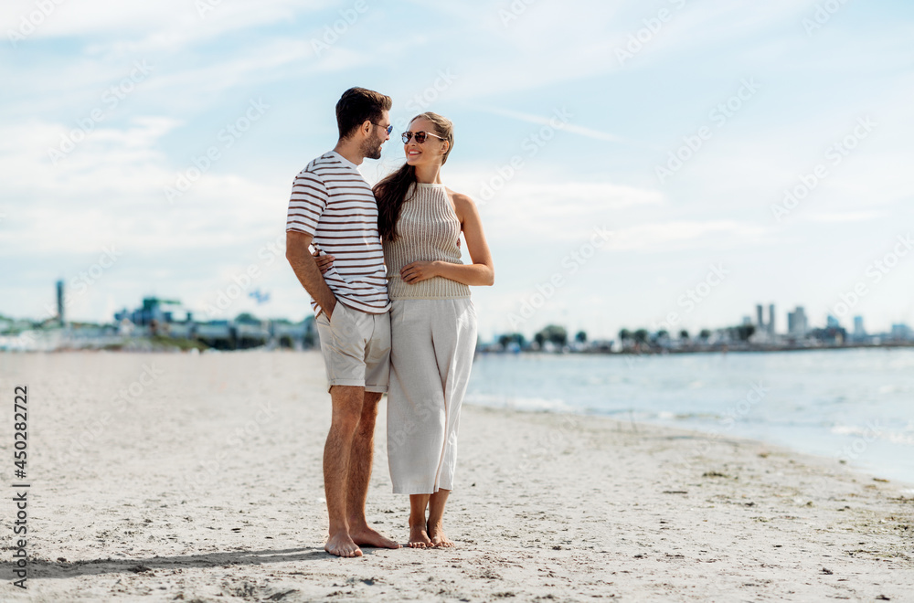 summer holidays and people concept - happy couple on beach in tallinn, estonia