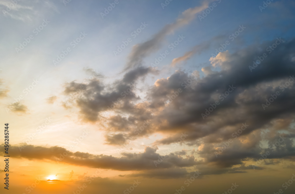 Obraz premium Bright colorful sunset sky with setting sun and vibrant clouds.