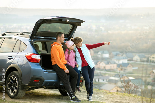 Family standing near car and enjoying nature. © bilanol