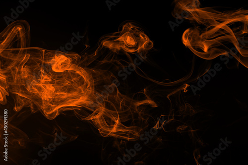 Fluffy puffs of orange smoke and fog on black background, fire design