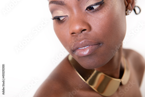 Beautiful young african america. Beauty portrait of charming girl with golden neck jewelry, studio shot over white background photo