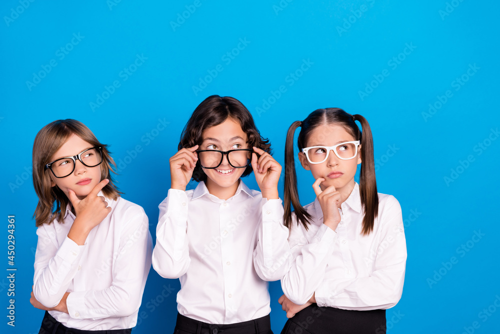 Photo of positive minded thoughtful kids look empty space wear school uniform isolated blue color background Photo of positive minded thoughtful kids look empty space wear school uniform isolated blue color background