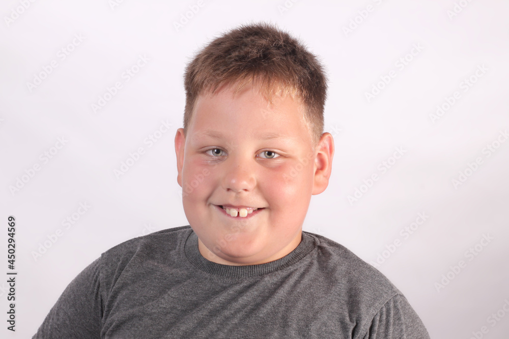 Happy smiling boy with autism disease on light gray background looking at camera Happy smiling boy with autism disease on light gray background looking at camera