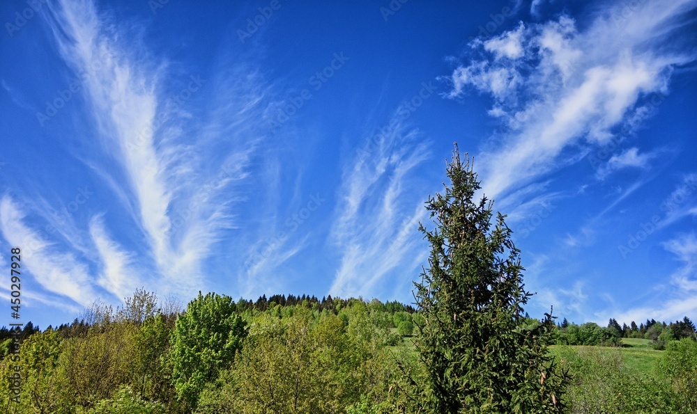 Obraz premium Clouds over the Ochotnica Gorna vilage hills during summer day