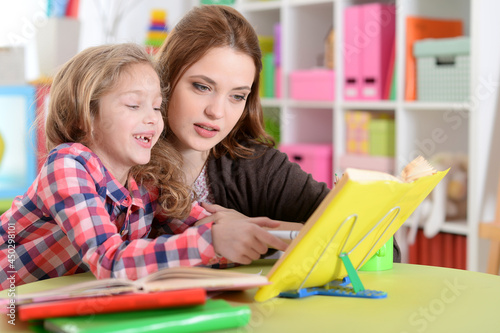 Cute little girl with her mother doing homework