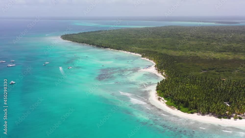 Dolphin point in Saona Island Dominican Republic with boats on the turquoise colored waters, Aerial wide pan right shot Dolphin point in Saona Island Dominican Republic with boats on the turquoise colored waters, Aerial wide pan right shot