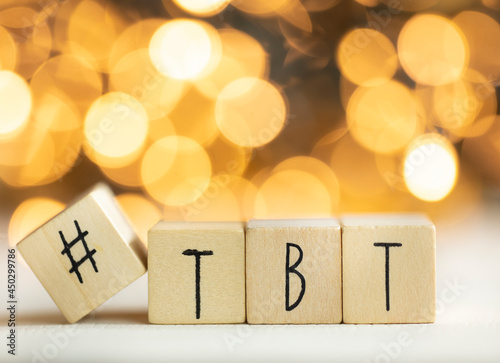 Hashtag TBT throwback Thursday written with wooden cubes with shiny bokeh background, social media concept photo