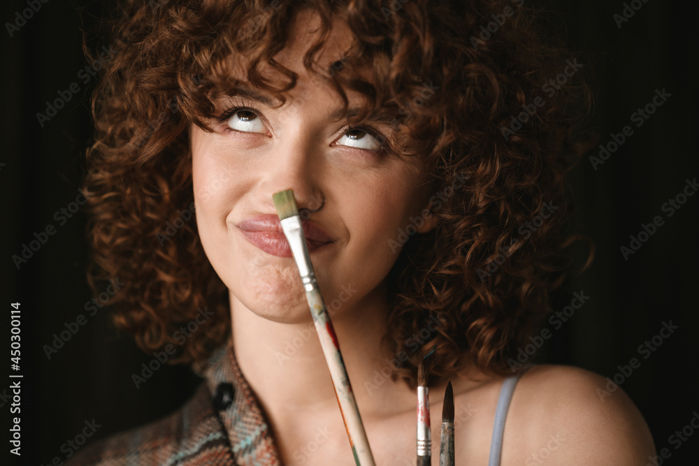 Obraz premium Smiling young redhead woman in plaid shirt