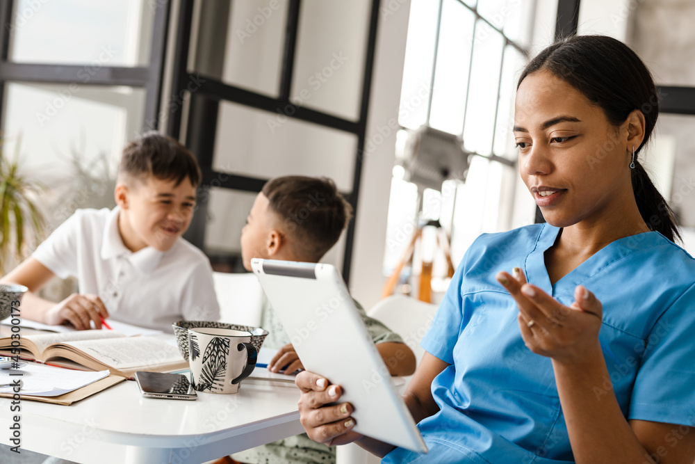 Black woman doctor using tablet computer while sitting at table Black woman doctor using tablet computer while sitting at table