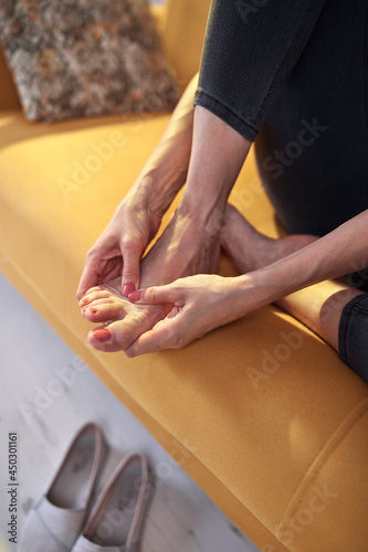 Woman with foot pain injury at home.