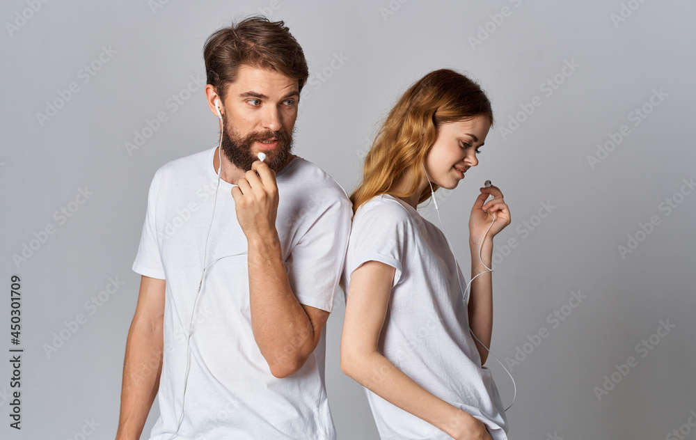 man and woman in white t-shirts are standing next to friendship music in headphones