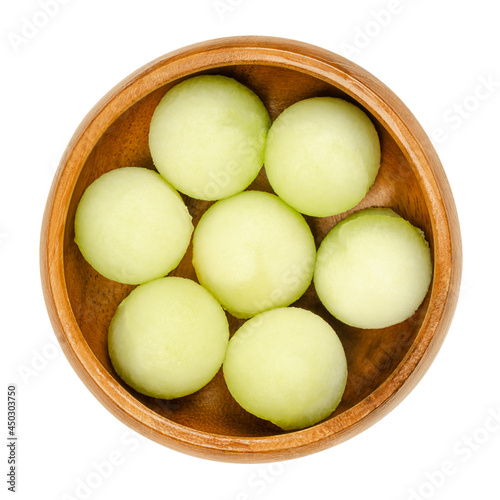 Galia melon balls, in a wooden bowl. Freshly cut out with a melon baller, ready-to-eat pieces of a ripe fruit of Cucumis melo var. reticulatus, a sweet and aromatic melon, also known as sarda. Photo. photo