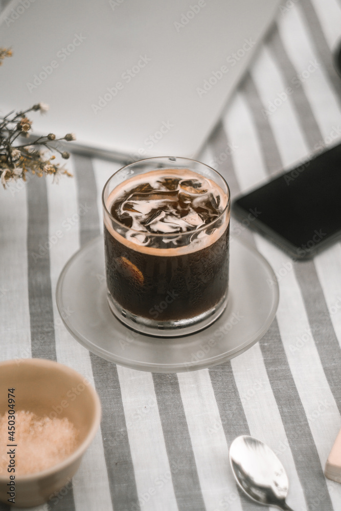 a glass of morning americano on the table with other accessories a glass of morning americano on the table with other accessories