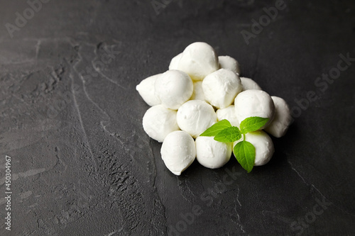 Mozzarella cheese balls with fresh basil on dark concrete background