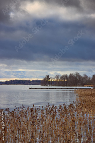 Late autumn heavy clouds forest reeds on Tuusula lake.
