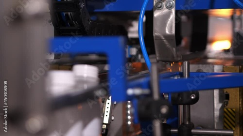 Honed automated operation of the blue machine on the conveyor production of plastic bottles.