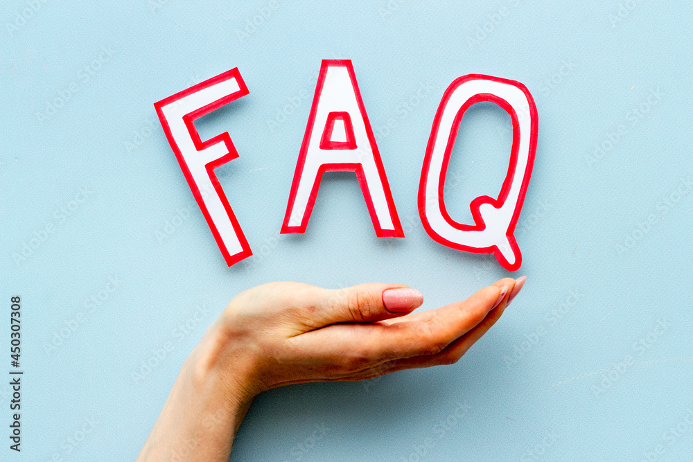 Hands with faq - frequently asked questions - paper letters, top view Hands with faq - frequently asked questions - paper letters, top view