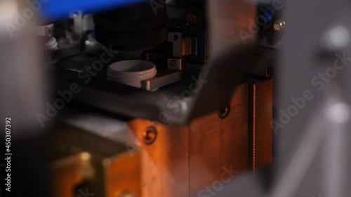 Honed automated operation of the blue machine on the conveyor production of plastic bottles. Production of a blank in the form of a white plastic bottle close up,