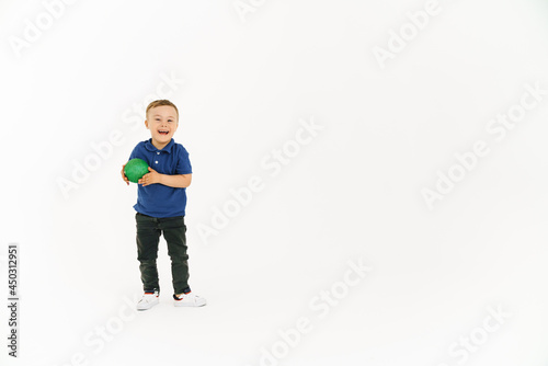 Boy with down syndrome holding toy and smiling at camera