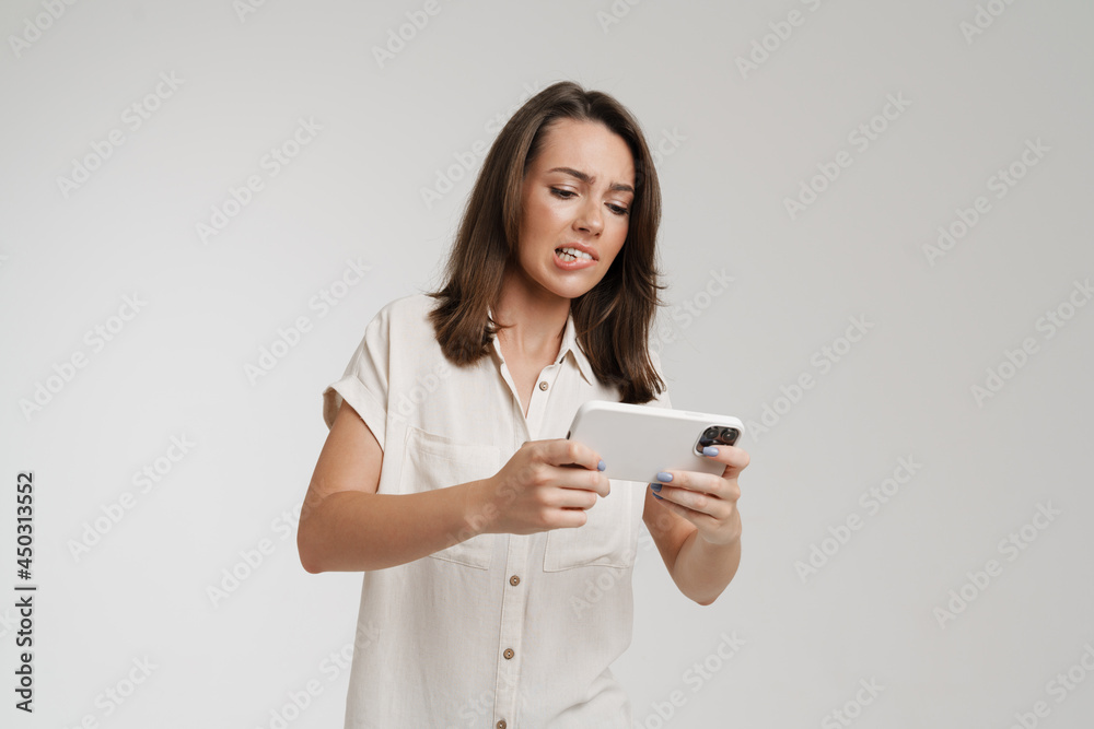 Young european woman playing video game on cellphone Young european woman playing video game on cellphone