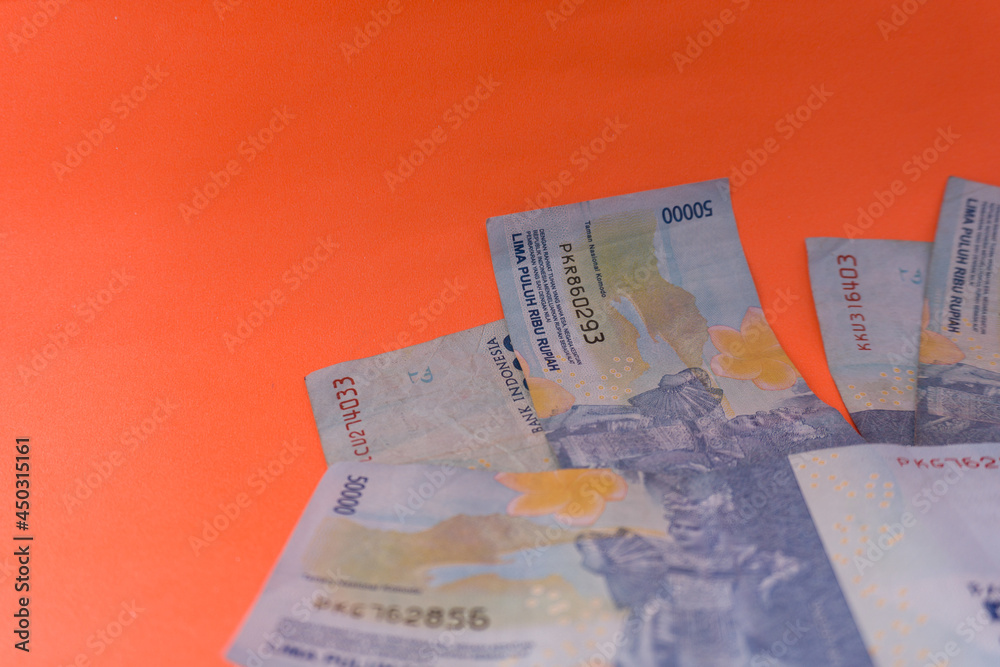 Obraz premium The Indonesian currency is rupiah, which is very much scattered and is worth fifty hundred thousand rupiah. Isolated in orange. For illustrations of news with the theme of economy, buying sell.