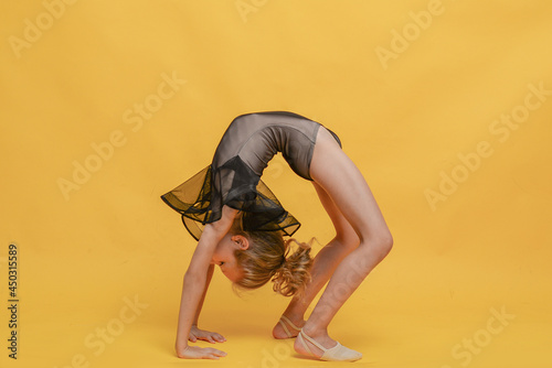little gymnast performs the exercise. The concept of sports, gymnastics, fitness.
