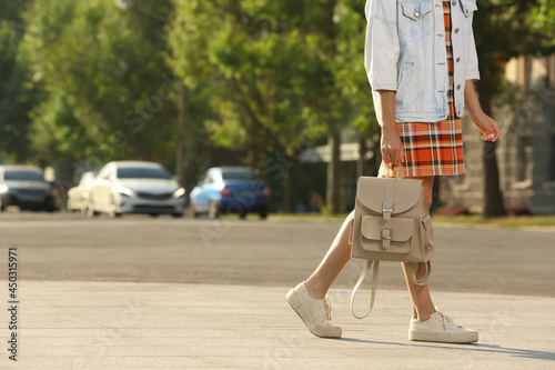 Young woman with stylish beige backpack on city street, closeup. Space for text