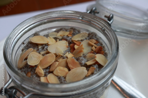 Chia seed pudding with sliced almonds in a glass jar. Close up. 