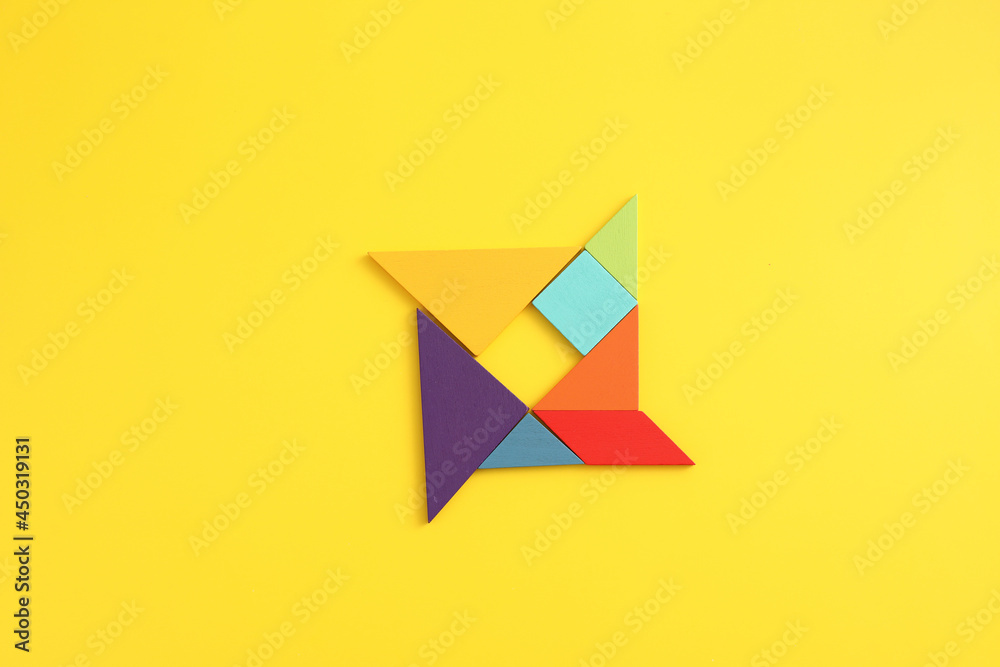 Wooden blocks windmill isolated in yellow background Wooden blocks windmill isolated in yellow background