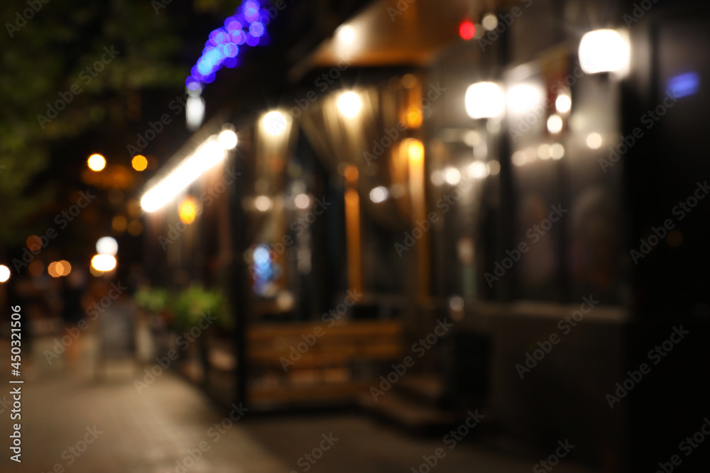 Blurred view of modern cafe with outdoor terrace at night