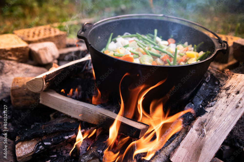 Dutch oven cooking on a campfire with open lid and stew Dutch oven cooking on a campfire with open lid and stew