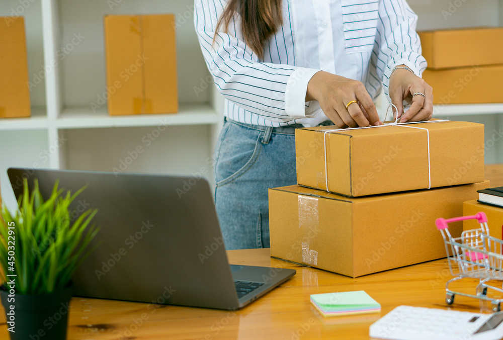 A young start-up, a small business owner, works with cardboard boxes at work. SME entrepreneurs or independent Asian people working at home online shopping delivery concept A young start-up, a small business owner, works with cardboard boxes at work. SME entrepreneurs or independent Asian people working at home online shopping delivery concept