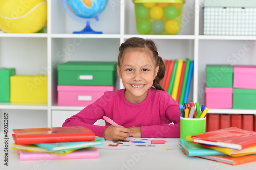 Porait of cute girl drawing picture at home