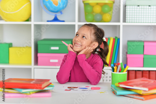 Porait of cute girl drawing picture at home