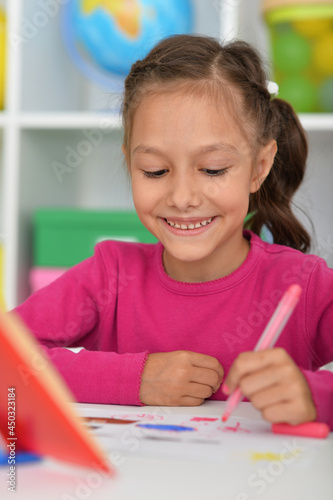 Porait of cute girl drawing picture at home