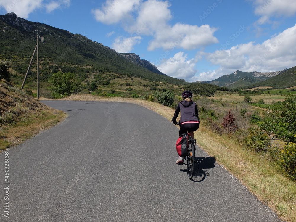 Obraz premium jeune femme à vélo qui randonne en itinérant à bicyclette dans le sud de la France