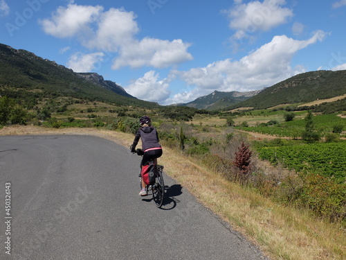 jeune femme à vélo qui randonne en itinérant à bicyclette dans le sud de la France