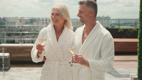 Mature couple enjoying champagne while relaxing in luxury hotel outdoors 