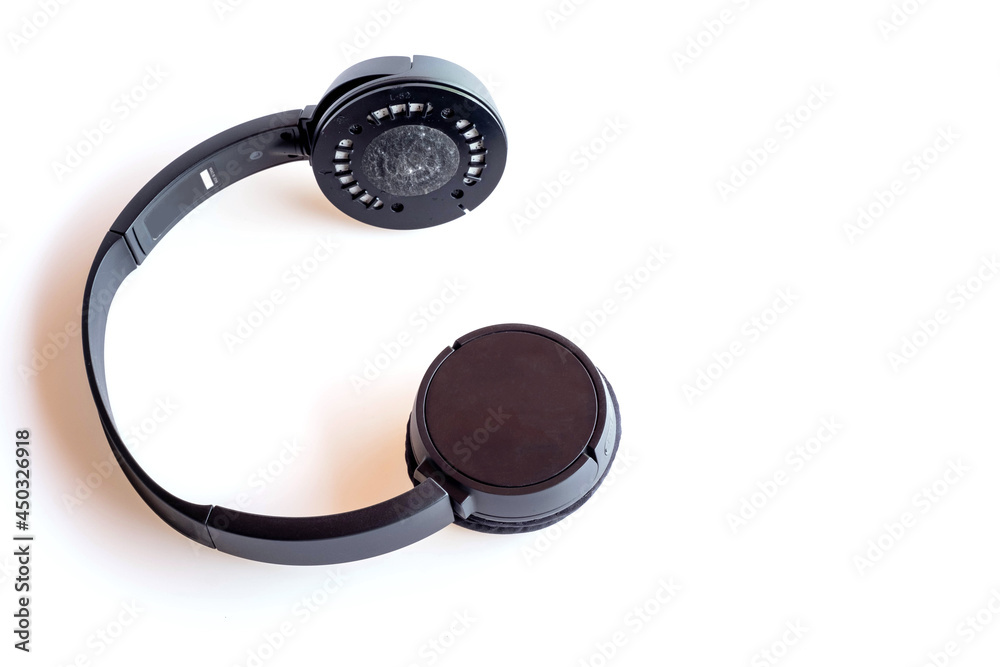 Black Bluetooth headphones isolated on white background, broken from use, macro Black Bluetooth headphones isolated on white background, broken from use, macro