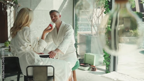 Mature couple enjoying breakfast together while spending time in the kitchen