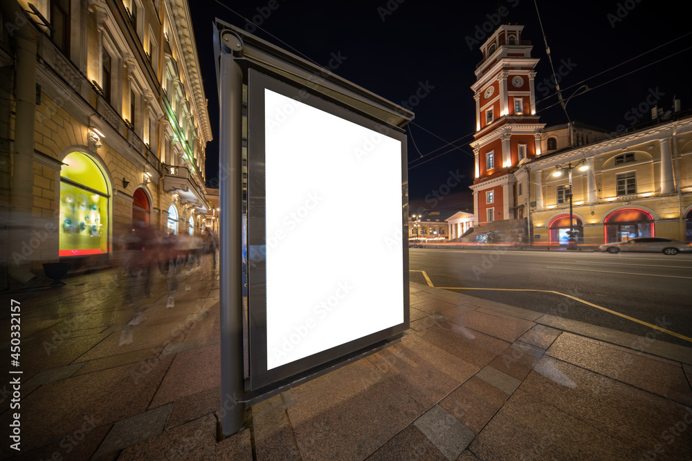 Billboard for a poster on the background of the city at night. At the bus stop mock-up.