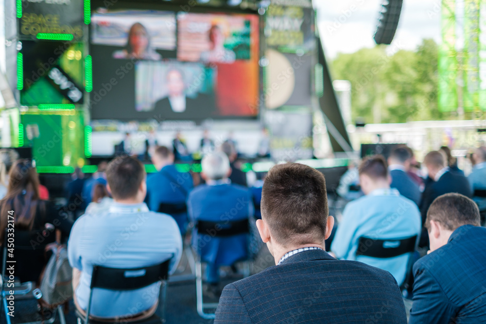 Fototapeta premium Participants of open air conference listening to speaker