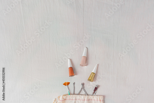 Lifestyle flat lay, top view, composition with nail polish, cotton bag and manicure tools. Beauty blog, manicure concept.