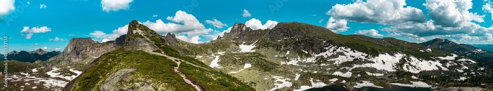 Panorama of snow-capped mountains in July in summer