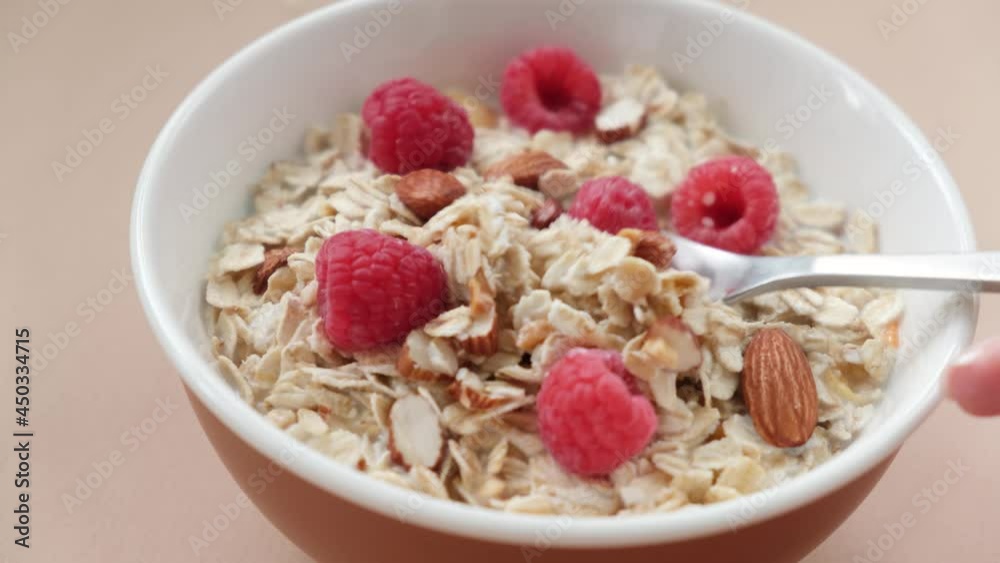 Muesli with raspberries in bowl. Eating healthy breakfast cereals oatmeal bowl Muesli with raspberries in bowl. Eating healthy breakfast cereals oatmeal bowl