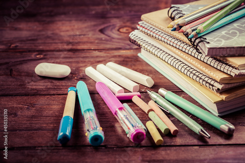 School supplies with exercise book and notepads on wooden background.
