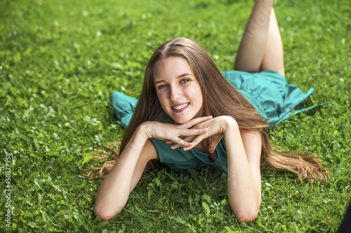 Portrait of a young girl lying on green grass
