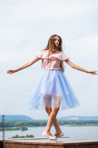 Portrait of a young stylish girl in blue skirt