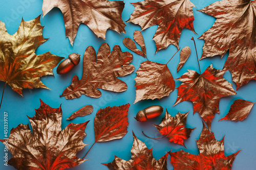 Top view of golden leaves on blue background